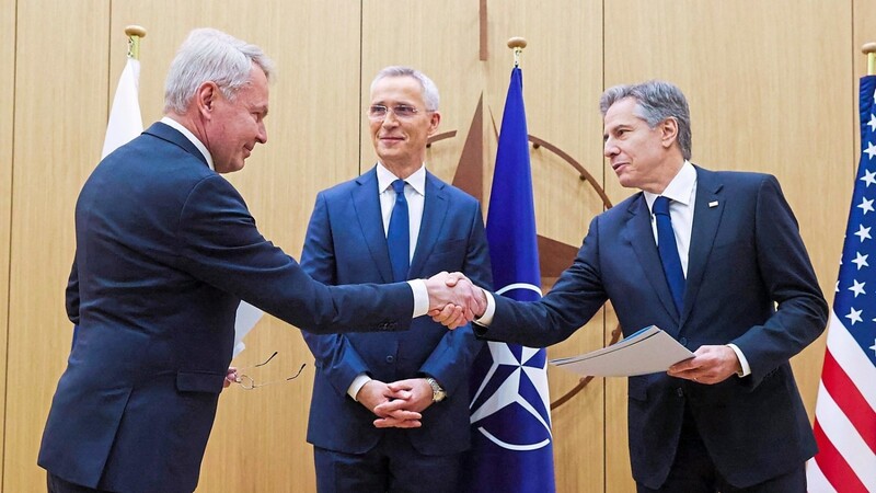 Finnlands Außenminister Pekka Haavisto (l.) übergibt US-Außenminister Antony Blinken (r.) im Beisein von Nato-Generalsekretär Jens Stoltenberg die Beitrittsurkunde seines Landes.