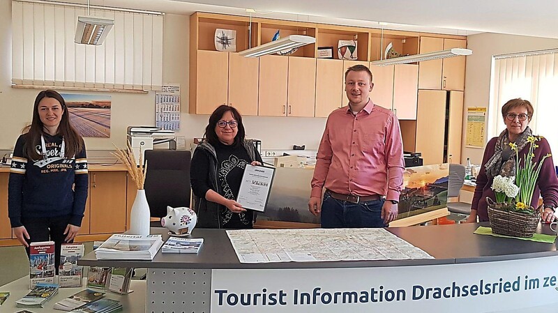 Tourist-Info-Leiterin Heidi Hupf (Mitte) hält die Urkunde "Barrierefreiheit geprüft" in ihren Händen. Mit ihr freut sich das Team mit Franziska Mühlbauer (li.) und Petra Geiger (re.) sowie Bürgermeister Johannes Vogl.