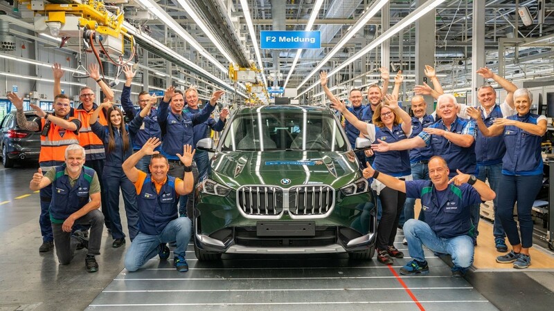 Mitarbeiter aus unterschiedlichen Bereichen des BMW-Werks Regensburg freuen sich über den Produktionsstart des neuen X1.