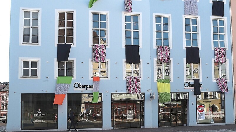 Neben weiteren Geschäften macht das Modehaus Oberpaur mit bunten Bannern auf die Situation des Einzelhandels aufmerksam.