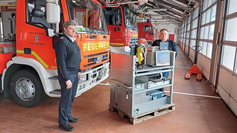 Kreisbrandrat Erwin Wurzer und Feuerwehrvorsitzender Tim Rothenwöhrer mit einem wichtigen Teil der Fahrzeugausrüstung - dem Computer. Er ist derzeit lose auf einer Holzpalette gelagert.