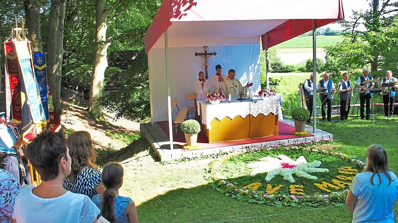 Pfarrer Vogl zeigte sich begeistert vom liebevoll gelegten Blumenteppich vor dem Altar im Freien.