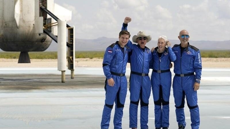 Oliver Daemen (l-r) aus den Niederlanden, Jeff Bezos, Gründer von Amazon und des Weltraumtourismus-Unternehmens Blue Origin, Wally Funk, ehemalige US-Pilotin, und Mark Bezos, Bruder von Jeff Bezos, stehen nach der Landung für ein Foto zusammen.