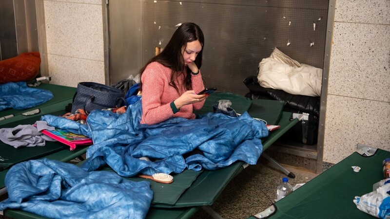 Olya, die aus der ukrainischen Stadt Charkiw geflüchtet ist, wartet nach ihrer Ankunft am Hauptbahnhof in einer Halle mit Feldbetten.