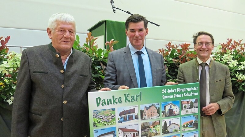 Hans Neumaier (links) und Bürgermeister Hans Sailer (rechts) überreichten Karl Ecker eine Leinwand-Collage mit "Spuren seines Schaffens".