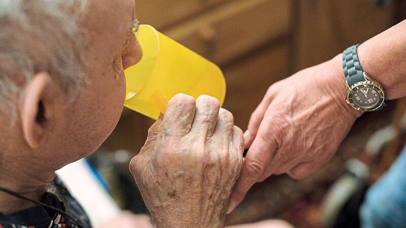 Eine ambulante Pflegerin hilft einem alten Mann bei der Tabletteneinnahme. Viele alte und kranke Menschen benötigen, um ihren Alltag Zuhause organisieren zu können, einen ambulanten Pflegedienst. (Symbolbild)