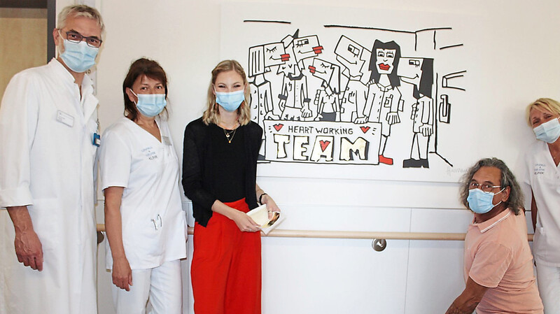 Ein Bild für die Anerkennung der Leistung der Pflegekräfte. Mit im Bild sind Chefarzt Thomas Beer (links), Kunststudentin Lara (Dritte von links) und Künstler Herman Reichold (Zweiter von rechts).