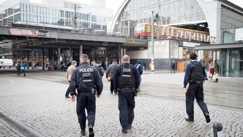 Polizeibeamte gehen am 04.02.2016 über den Alexanderplatz in Berlin. Mit mehreren Razzien ist die Polizei am Donnerstag bundesweit gegen mutmaßliche islamistische Terroristen vorgegangen. Nach Angaben der Berliner Staatsanwaltschaft sei auch ein Anschlag in Berlin geplant gewesen.