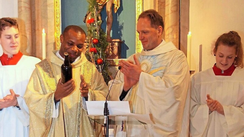 Pfarrer Stefan Wissel hieß Pfarrvikar Reginald Uzoho mit einem Craft-Bier in der Gemeinde willkommen.