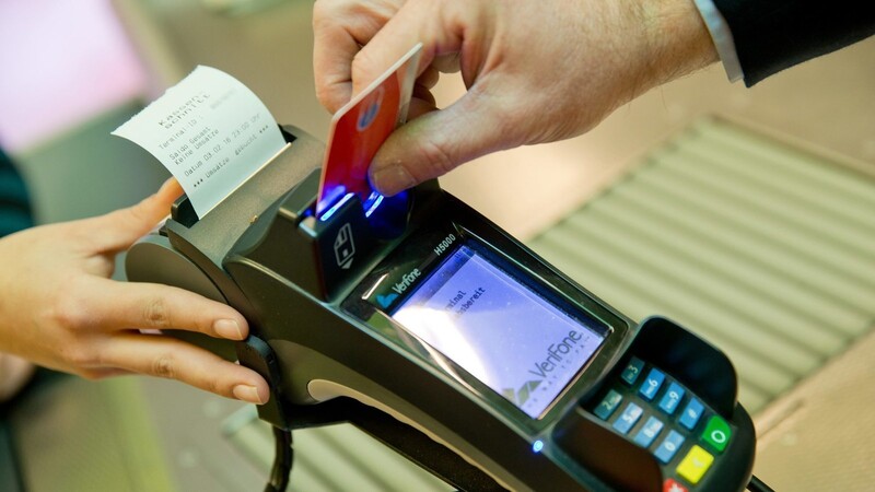 Ein Kunde zahlt in einem Supermarkt mit einer EC-Karte an der Kasse.