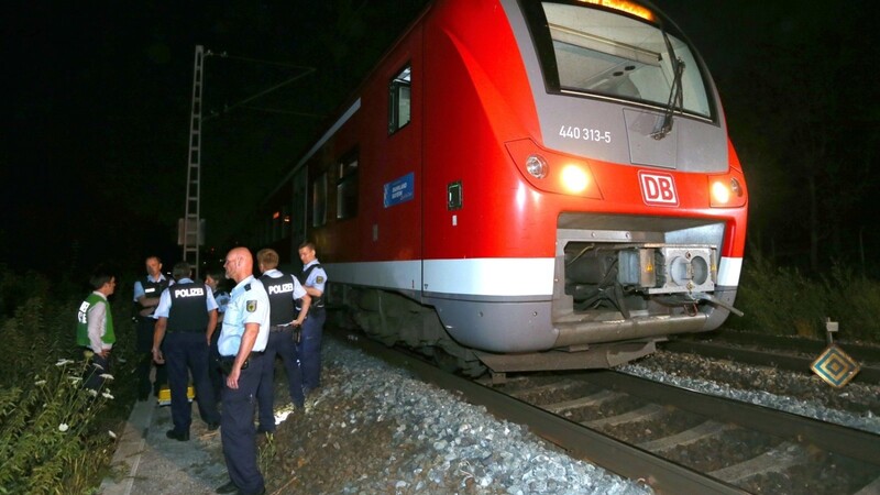 Polizisten stehen in Würzburg neben einem Regionalzug. Ein Mann hatte in dem Zug vor genau fünf Jahren Reisende angegriffen und mehrere Menschen lebensgefährlich verletzt. Nach der Attacke wurde der Täter von der Polizei auf der Flucht erschossen.