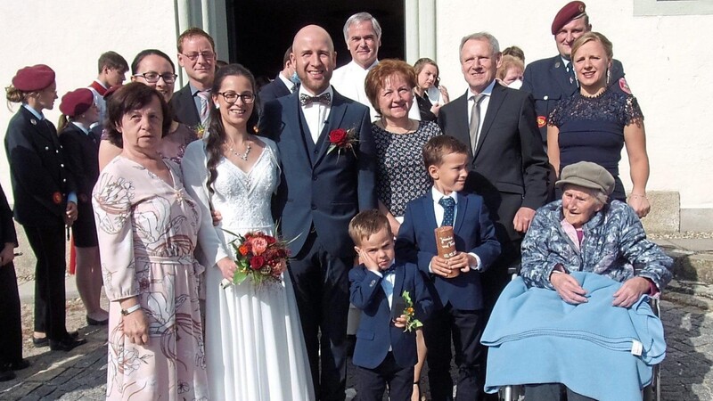 Das glückliche Brautpaar mit ihren Angehörigen, Pfarrer Pöschl und den beiden Spielmannszugleitern Stefan Wurm und Josef Breu