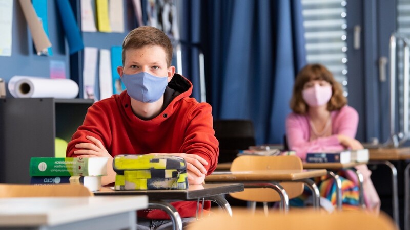 Schüler eines bayerischen Gymnasiums sitzen mit Maske im Unterricht. Für zwei Wochen wird das im Freistaat Pflicht sein.