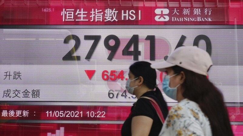 Menschen gehen an der elektronischen Tafel einer Bank vorbei, die den Hongkonger Aktienindex an der Hongkonger Börse anzeigt. Massive und wahllose Eingriffe des Staates in Unternehmen haben vergangene Woche zu einem beispiellosen Rückzug aus chinesischen Börsenwerten geführt.