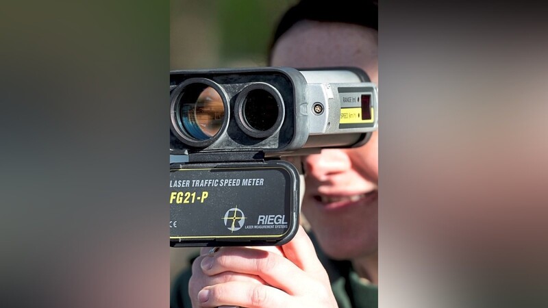 Die Polizeihauptmeisterin Christina Nitsch schaut im Rahmen einer Geschwindigkeitsmessung durch ein Lasergerät.