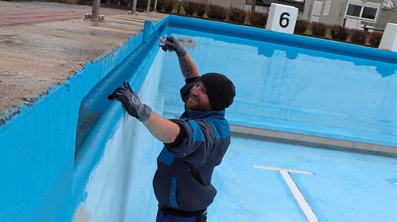 Blaue Farbe statt kühlem Nass: Schwimmmeister Alexander Hofmann legt beim Renovieren des Beckens selbst Hand an und schwingt die Farbrolle.