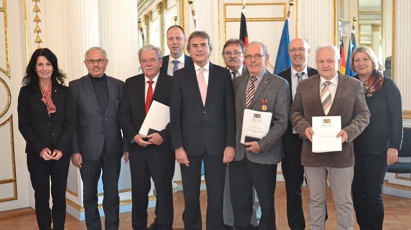 Ausgezeichnet wurden (mit Urkunden, v. l.) Hermann Vanino, Michael Jobst und Albert Baldauf. Regierungspräsident Axel Bartelt (m.) und kommunale Vertreter gratulierten.