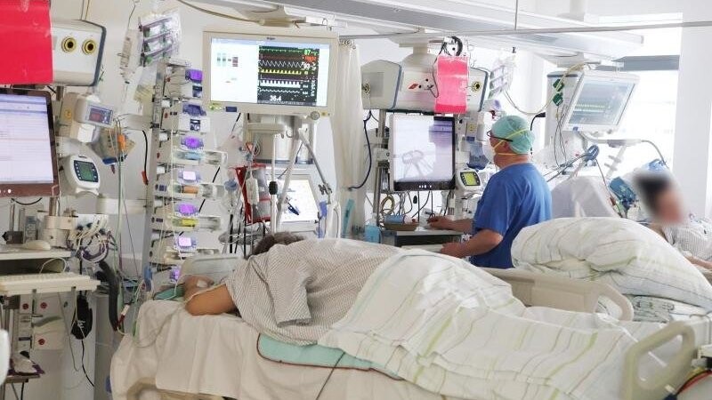 Ein Pfleger untersucht einen Patienten auf der Covid-19-Intensivstation einer Klinik in Gera.