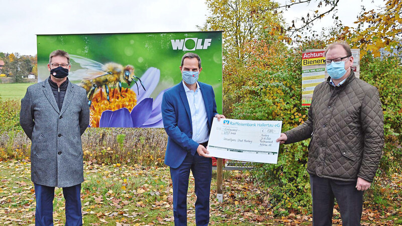 Bürgermeister Helmut Fichtner (links) und Raiffeisen-Vorstand Florian Maier (rechts) überreichten an Wolf-Chef Thomas Knaup den Preis.