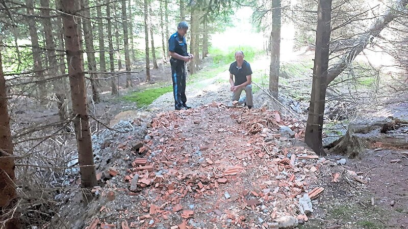 Mit jeder Menge Bauschutt wurde diese Senke im Fichtenwald aufgefüllt. Polizei-Hauptkommissar Rudi Schmidbauer (links) und BN-Chef Konrad Pöppel bei der Überprüfung des Materials.