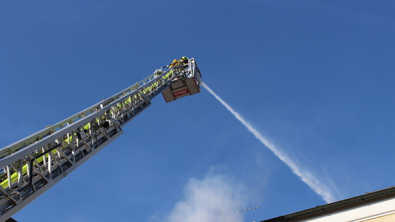 Der Brandherd am Dach wird von der Drehleiter aus gelöscht.