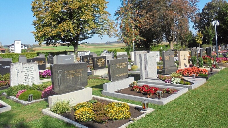 Mit schönem Blumenschmuck versehene Gräber auf dem Friedhof. Das Gelände und die Grabstätten sind stets in einem sehr gepflegtem Zustand.