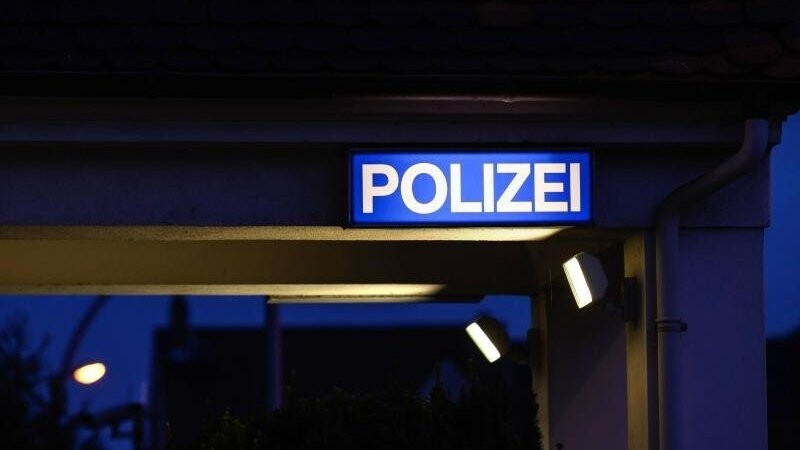 Ein Schild mit der Aufschrift "Polizei" leuchtet am Eingangsbereich der Polizeistation. (Symbolbild)
