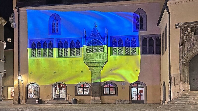 Regensburg zeigt sich solidarisch mit der Ukraine: Die Außenwand des Reichsaals ist blau-gelb beleuchtet.