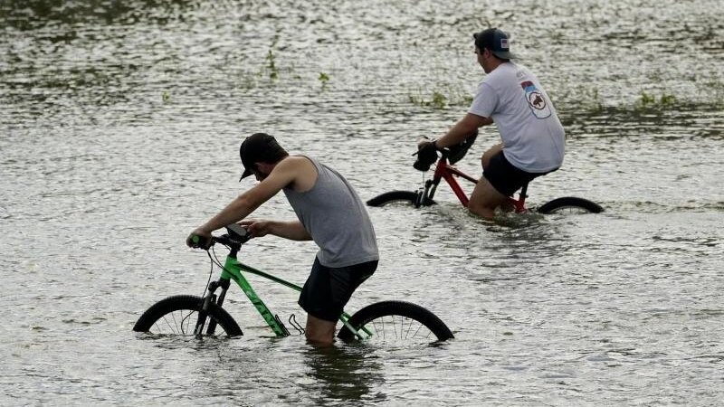Radfahrer radeln durch die Überschwemmungen des Hurrikans "Ida" in der Nähe des Yachthafens von New Orleans.