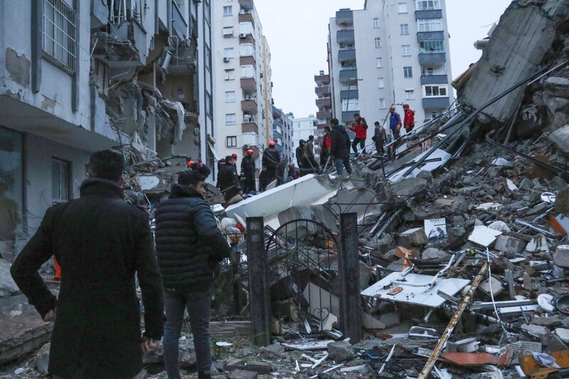 Menschen und Rettungsteams versuchen in Adana, eingeschlossene Bewohner in eingestürzten Gebäuden zu erreichen. 