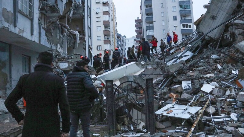 Menschen und Rettungsteams versuchen in Adana, eingeschlossene Bewohner in eingestürzten Gebäuden zu erreichen.