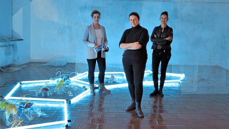 In blauem Licht: Elizabeth Thallauer (Mitte) mit Simone Seifert (links), der Kuratorin der Ausstellung, und Galerieleiterin Anjalie Chaubal.