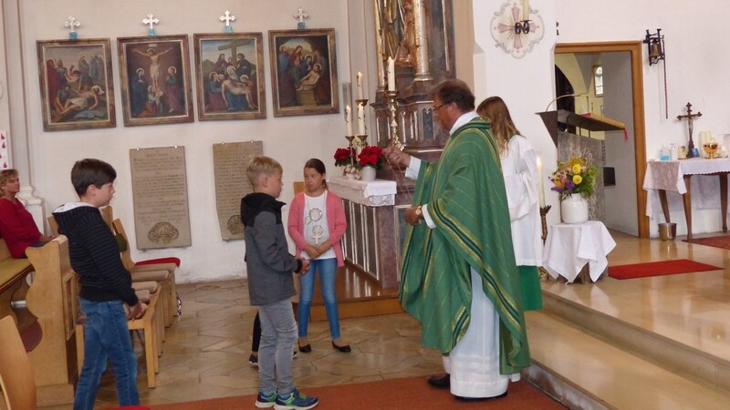 Jedes der Kommunionkinder erhielt von Stadtpfarrer Josef Ofenbeck das Kreuz als Zeichen für die Verbindung mit Christus umgehängt.