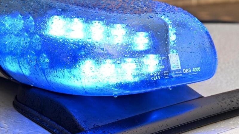 Ein Streifenwagen der Polizei steht mit eingeschaltetem Blaulicht an einem Einsatzort.