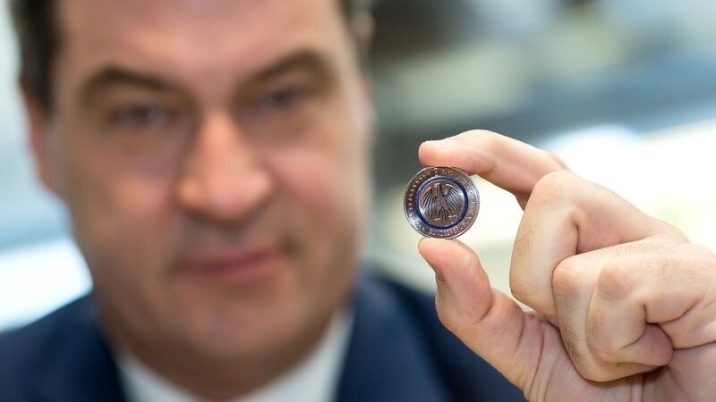 Der bayerische Finanzminister Markus Söder (CSU) hält am 11.04.2016 im Hauptmünzamt in München (Bayern) die neue Fünf-Euro-Münze "Blauer Planet Erde" in der Hand.