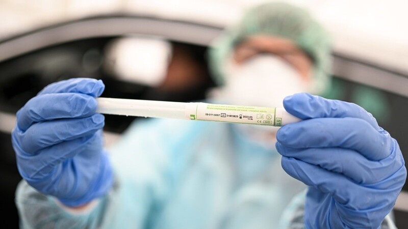 Eine Arztin hält einen Abstrichstäbchen im Plasikröhrchen in den Händen, nachdem sie einem Patienten in einem Testzentrum am Ortsrand unter einem Zelt einen Abstrich aus dem Rachen entnommen hat. Der Abstrich wird im Anschluss auf das neuartige Coronavirus getestet.