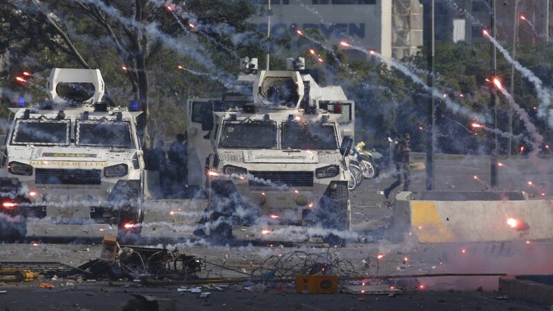 Feuerwerkskörper, die von Gegnern des venezolanischen Präsidenten Maduro während eines versuchten militärischen Aufstands geworfen worden sind, landen nahe gepanzerter Fahrzeuge der Nationalgarde.