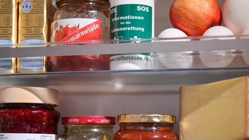 Eine Notfalldose steht neben Lebensmitteln in einer Kühlschranktür. Foto: Patrick Pleul/ZB/Archiv