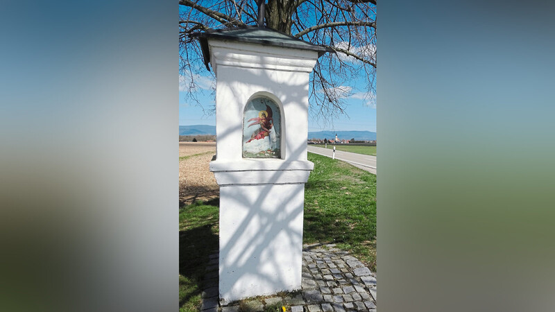 Ein eindrucksvolles Denkmal der Nachbarschaftshilfe, die "Weiße Marter" zwischen Irlbach und Straßkirchen mit Irlbach im Hintergrund.