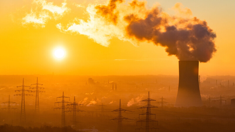Deutschland steht beim Klimaschutz unter Druck: Die Sonne geht neben dem Kühlturm eines Kraftwerks bei Recklinghausen auf.