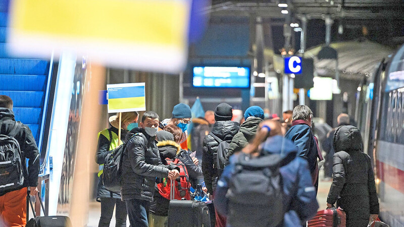Geflüchtete werden an einem Bahnhof von Ehrenamtlichen mit Schildern in Empfang genommen. Auch in Bayern kommen immer mehr Menschen aus der Ukraine an.