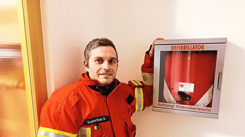 Kommandant Stefan Schuberthan vor dem Defibrillator an seinem neuen Platz im Pfarrheim.