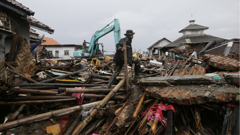 Ein indonesischer Soldat sucht in den Trümmern nach Tsunami-Opfern.