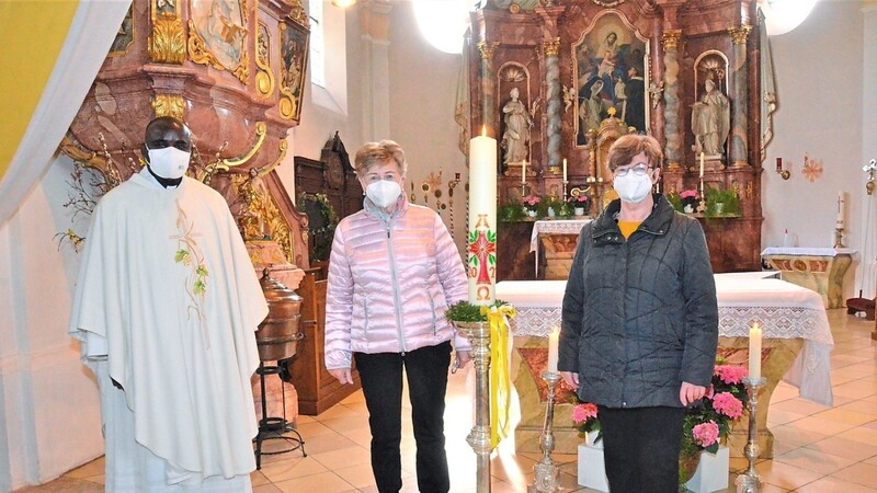 30-jähriges Kerzenjubiläum: Pfarrvikar Pater Kessington Anyanwu bedankte sich bei den beiden Frauen Christa Dippold (rechts) und Hertha Zelenka (Mitte) für das alljährliche Gestalten der Osterkerze.