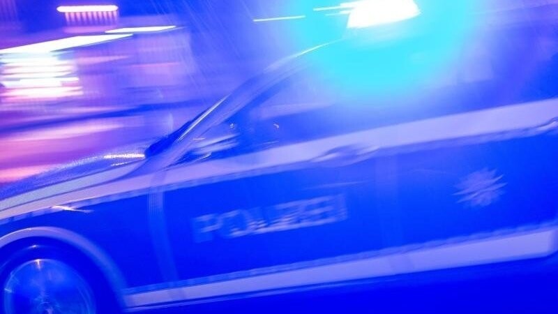Ein Polizeiauto fährt im Einsatz mit Blaulicht über eine Straße. (Symbolbild)
