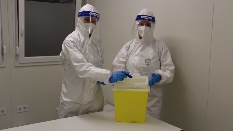 In der Teststation Am Hagen entsorgen zwei Fachkrankenpflegerinnen für Anästhesie die benutzten Testkassetten in einer Medibox.