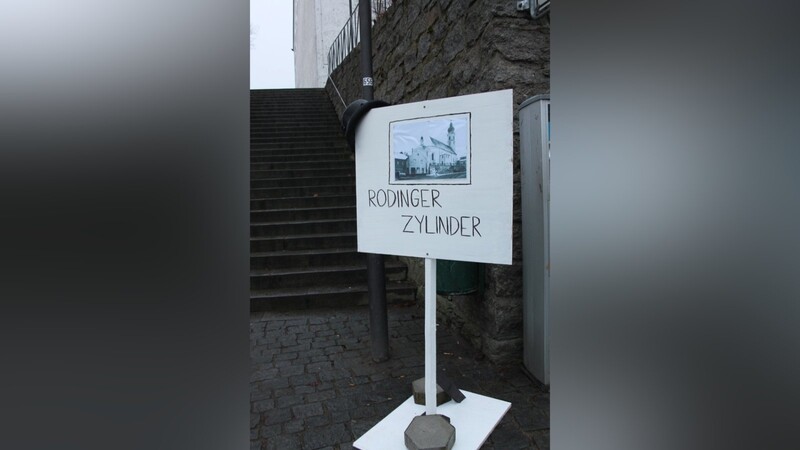 An der Treppe zur Pfarrkirche steht ein Schild mit altem Foto. (Foto: al)