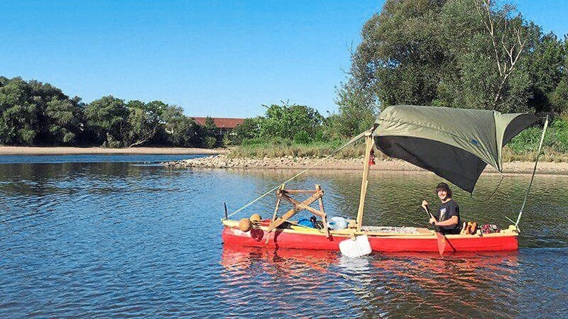 Mit seinem roten Kanu mit dem grünen Sonnenschutz will Jonathan Pielmeier von Bogen bis nach Wien fahren. Im Gepäck hat er seine Holzhanteln.