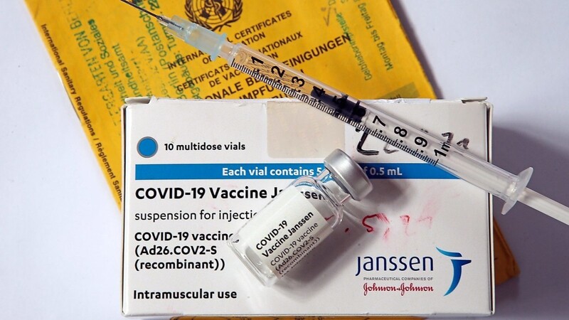 Eine Spritze und eine Ampulle des Impfstoffs von Johnson & Johnson gegen das Coronavirus liegen auf einer Verpackung des Impfpräparats.