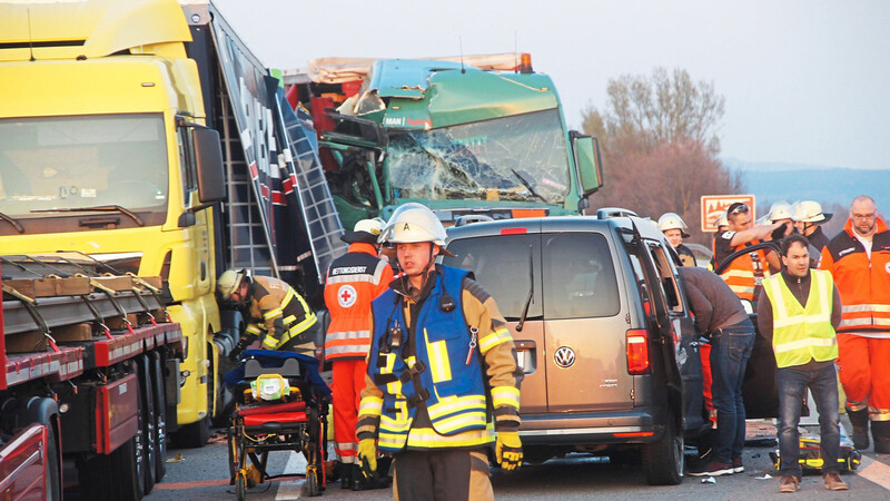 Wörther Feuerwehrleute, Notärzte und Sanitäter an der Unfallstelle. Im Hintergrund ist der grün-rote Gefahrguttransporter zu erkennen.